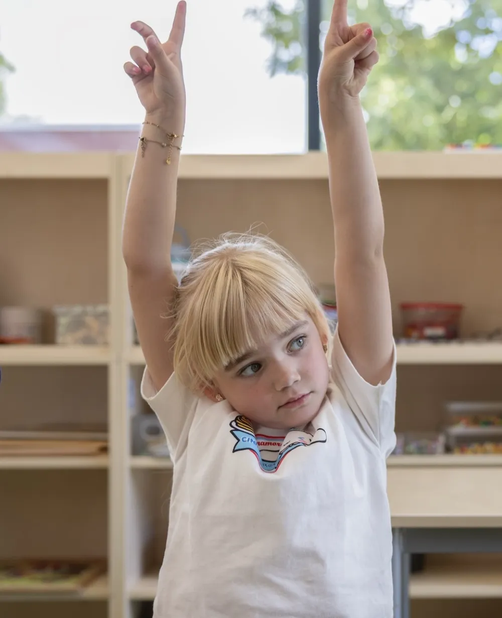 meisje steekt vinger op in de klas